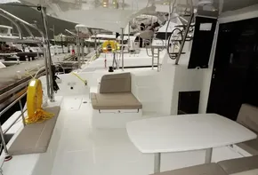 Lagoon 42 catamaran 2020 model, spacious deck with seating and table, docked at marina.