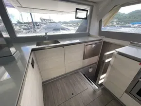 Modern kitchen interior on a 2020 Leopard 50 yacht, featuring sleek cabinetry and scenic marina views.