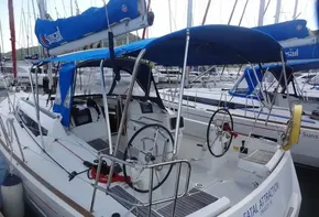 2017 Jeanneau Sun Odyssey 389 sailboat docked with blue canopy and dual steering wheels.