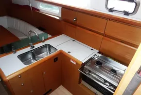 Modern kitchen in 2017 Jeanneau Sun Odyssey 389 sailboat with sink and stove.