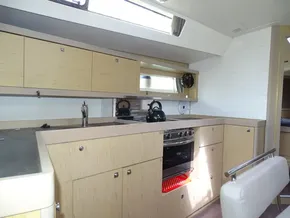 Modern kitchen interior of 2017 Beneteau Oceanis 45 yacht with light wood cabinetry.
