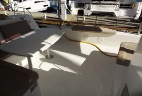Lagoon 42 catamaran 2020 model, spacious cockpit with seating and table, docked at marina.