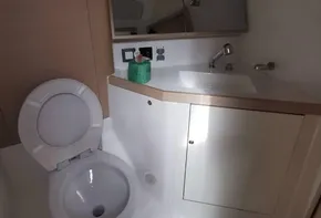 Beneteau Oceanis 46.1 2020 yacht bathroom with toilet, sink, and mirrored cabinet.