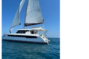 Sailing catamaran Leopard 42, 2022 model, gliding on clear blue ocean waters.