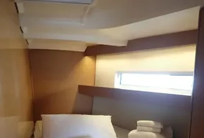 Cozy cabin interior of 2019 Jeanneau Sun Odyssey 440 yacht with neatly arranged bedding.