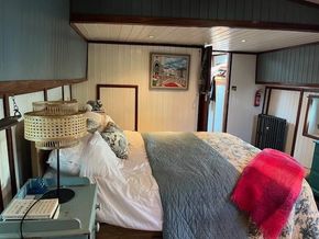 Cozy bedroom interior of a 1901 Classic Dutch Barge with vintage decor and soft lighting.