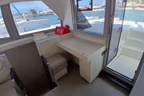 Interior of 2018 Leopard 45 catamaran with desk, window view, and outdoor access.