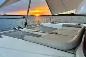 2024 Lagoon 42 catamaran at sunset, featuring spacious deck and comfortable seating.
