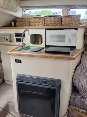 Fridge at bottom, sink with h/c mixer tap, electric pump induction hob microwave stereo radio/usb player