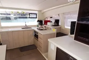 Modern kitchen interior of 2017 Leopard 43 Powercat yacht with large windows and light wood cabinetry.