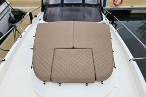 2023 Balt 818 Titanium boat with quilted tan deck cushions at a marina.