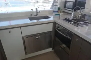 Modern kitchen in 2022 Leopard 45 yacht with stainless steel appliances and sleek countertops.
