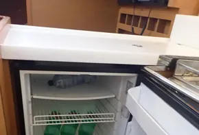 Open fridge with drinks inside on Jeanneau Sun Odyssey 440 yacht, 2019 model.