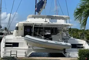 2020 Leopard 50 catamaran with dinghy, docked at marina under clear blue sky.
