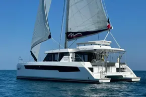2022 Leopard 42 catamaran sailing on open sea under clear blue sky.