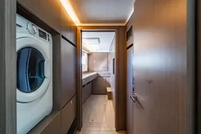 Modern laundry area inside 2025 Leopard 46 yacht, featuring sleek wood paneling and washer.