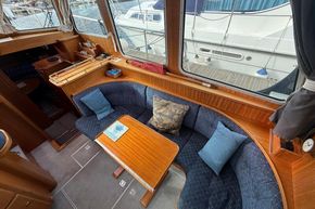 Cozy interior of 1994 Linssen 360 AC yacht with plush seating and wooden table.