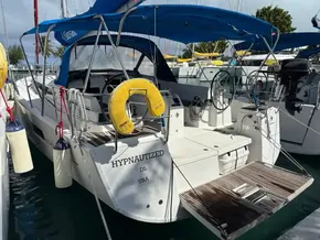 2019 Jeanneau Sun Odyssey 440 sailboat docked, featuring blue canopy and safety equipment.
