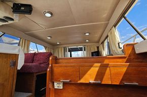 Interior of 1989 Princess 35 Flybridge yacht with wood cabinetry and plush seating.