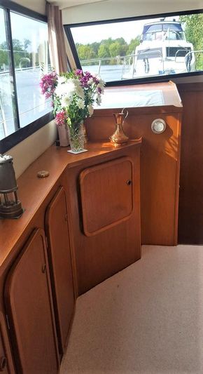 Interior of 1995 Aquafibre Bounty Boats 10/70 with wooden cabinetry and floral decor.
