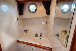 Bathroom interior of 2005 Stevens 1200 Vlet yacht with sink, mirror, and porthole window.