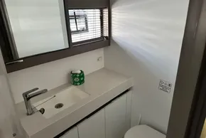 Modern bathroom interior on 2022 Leopard 53 Powercat yacht, featuring sleek sink and window blinds.