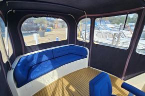 Interior of 2005 Stevens 1200 Vlet boat with blue seating and wooden flooring.