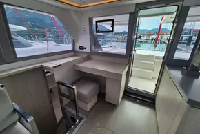 Modern interior of 2020 Leopard 45 catamaran with desk, seating, and marina view.