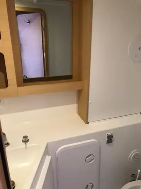 Modern bathroom in a 2020 Lagoon 42 catamaran with wooden accents.