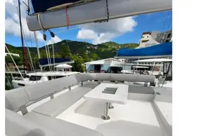 Spacious deck of 2020 Leopard 50 yacht with seating and table, docked in marina.