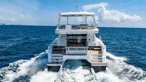 2025 Leopard 40 Powercat cruising on open sea, rear view, clear blue sky.