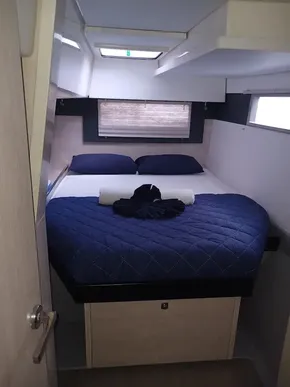Cozy bedroom in 2021 Leopard 40 yacht with blue bedding and natural light.