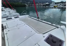 Leopard 45 catamaran docked in a scenic marina, showcasing spacious deck and netting.