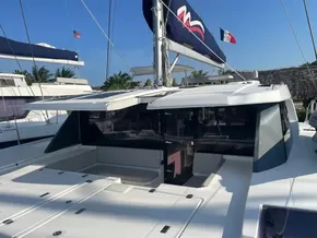 2021 Leopard 45 catamaran with spacious deck, sails, and tropical backdrop.