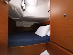 2019 Jeanneau Sun Odyssey 389 cabin interior with cozy bed and wooden finish.
