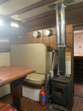 22/04/25 Saloon looking forward, port side: solid fuel stove, table lowers, joins bunk & converts to double berth