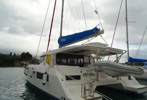 2017 Leopard 45 catamaran with blue sail, docked in calm waters.