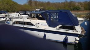 1982 Fairline Mirage 29 Aft Cabin boat docked with blue canopy.