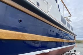 Port side looking aft; port engine breather topside left, water line 'idling' exhaust cowl visible in white boot topping line