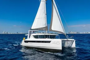 2025 Leopard 46 catamaran sailing on blue ocean near city skyline.