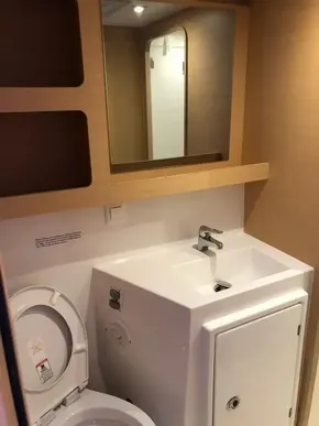 2020 Lagoon 42 yacht bathroom with sink, mirror, and toilet.