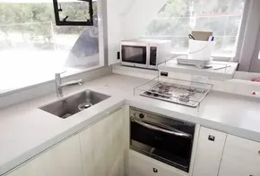 Modern kitchen in a 2017 Leopard 45 catamaran with sink, stove, oven, and microwave.