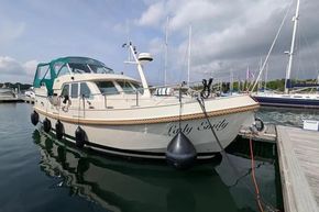 2008 Linssen Grand Sturdy 380 AC yacht docked at marina under cloudy sky.