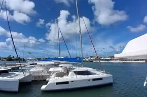 Leopard 45 catamaran docked in a marina under a clear blue sky.