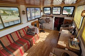 Interior of a 1927 Classic Dutch Barge with cozy seating and nautical decor.