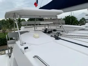 2021 Leopard 45 catamaran deck with canopy and rigging, docked near tropical greenery.