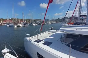 2022 Leopard 45 catamaran docked in a marina with sailboats and blue sky.