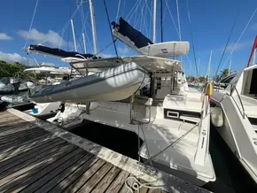 2019 Leopard 40 catamaran docked with dinghy, clear sky, and marina view.