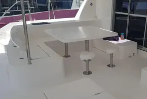 Leopard 48 2017 yacht interior with white seating, table, and stairs.
