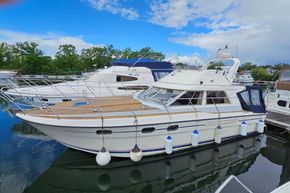 1989 Princess 35 Flybridge yacht docked, featuring sleek design and spacious deck.